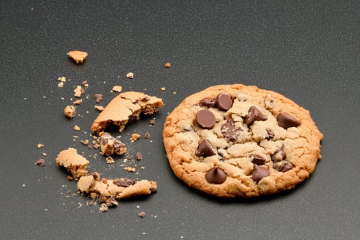 A cookie with chocolate chips on a black surface photo