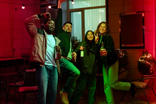 Friends celebrate at an evening gathering with drinks and laughter in a cozy outdoor setting photo