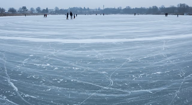 People are skating on an ice covered lake photo