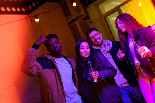 Friends enjoying a lively evening at a cozy indoor gathering with colorful lighting and drinks photo