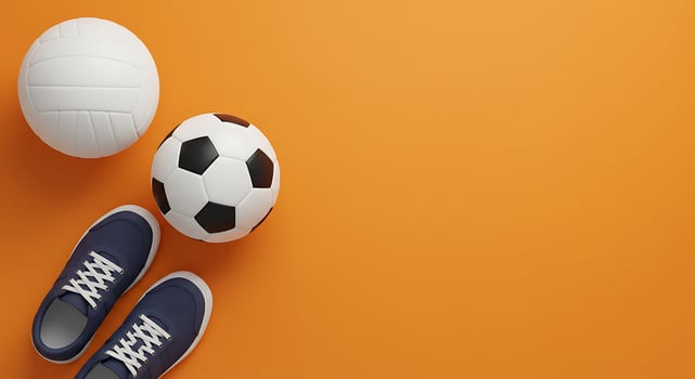 A pair of sneakers and a soccer ball on an orange background photo