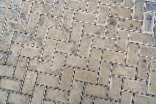Detailed view of textured paving stones in a city setting highlighting their unique patterns and wear marks photo