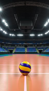 A volleyball ball sits on the court in an empty arena photo