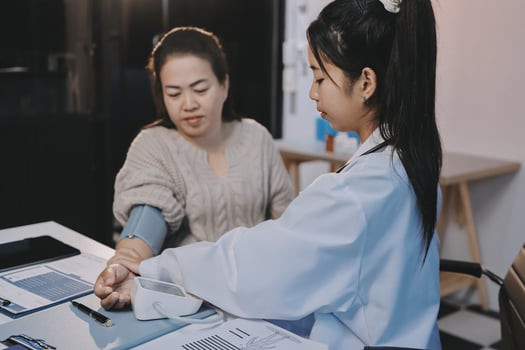 A woman is checking the blood pressure of another woman photo