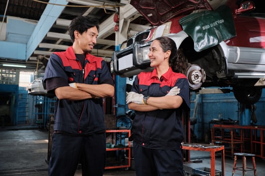 Happy professional teamwork, Latino female and Asian mechanic man workers are cheerful, looking together with smiles in fix car garage, and maintenance service jobs in auto transportation business. photo