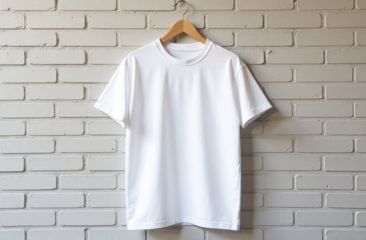 Minimalist white t-shirt displayed on a wooden hanger against a textured brick wall in a well-lit setting photo