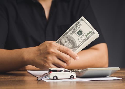 Car loan or Title loan. US dollar bills in a hand businessman while sitting at the table photo