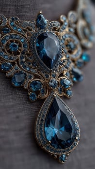 Intricate gold necklace adorned with stunning blue gemstones displayed on a textured surface photo