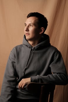 A Casual Portrait of a Thoughtful and Reflective Young Man Dressed in a Comfortable Hoodie photo