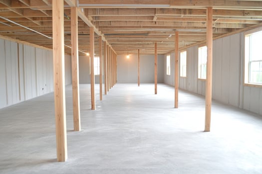 A large empty room with concrete floors and wooden beams photo