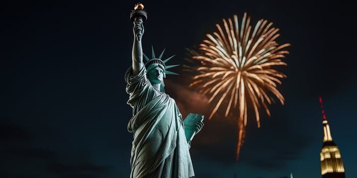 The statue of liberty is lit up with fireworks photo