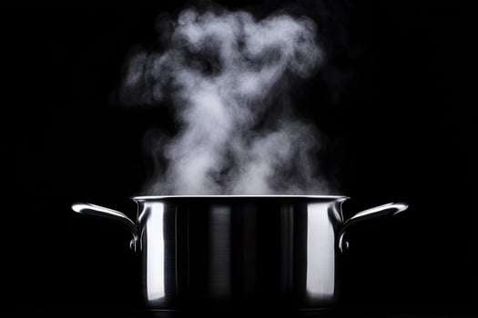 A pot with steam coming out of it on a black background photo