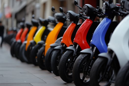 A row of motor scooters parked on a street photo