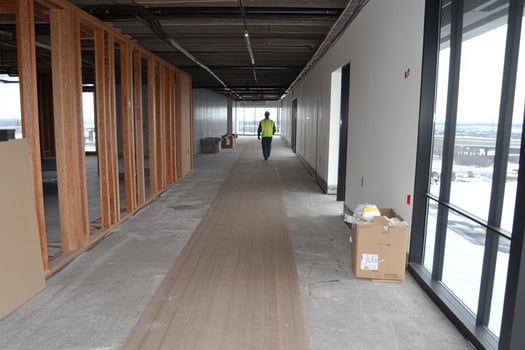 A man walking down a hallway with wood framing photo