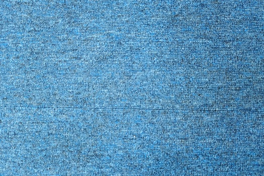 A close-up of a blue textured fabric with a subtle, speckled pattern. photo