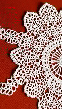 close up of a doily on a red surface photo