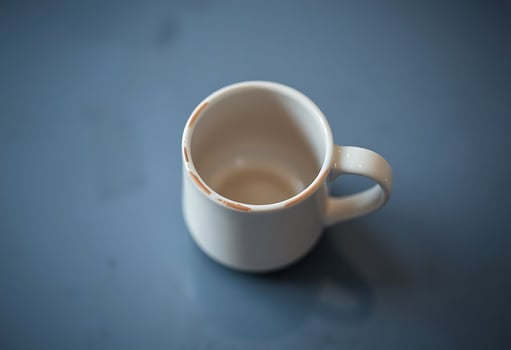 white cup sitting on top of a table photo