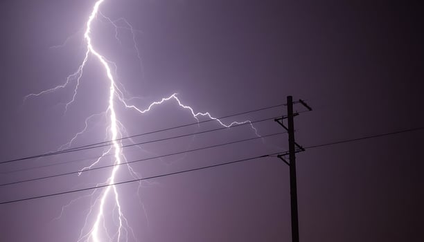 lightning bolt is seen in the sky above power lines photo