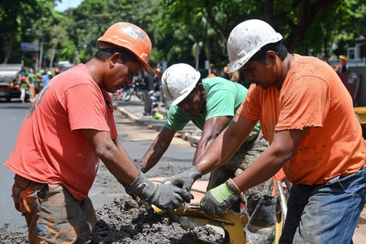 Three men working on a road with a pile of dirt photo