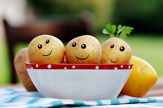 Three potatoes in a bowl with smiles on them photo