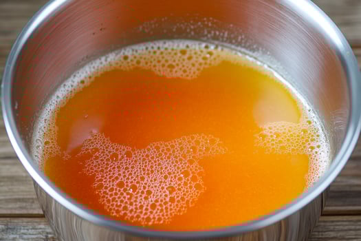 A silver cup with orange liquid in it photo