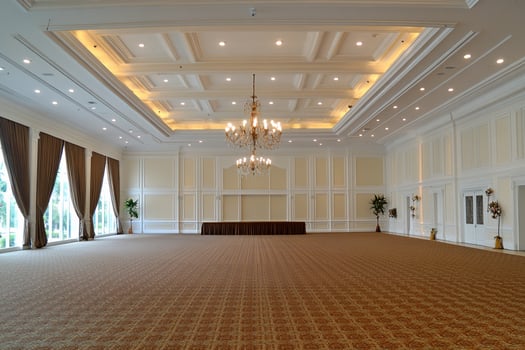 A large empty room with a chandelier and a table photo