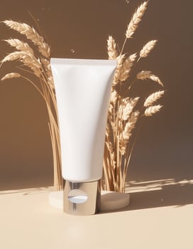 A tube of cream is sitting on a table with wheat photo