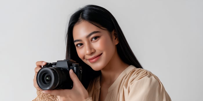A woman holding a camera and smiling photo