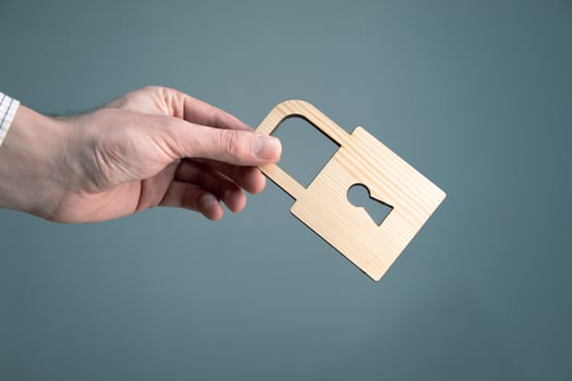A person holding a wooden padlock in their hand photo