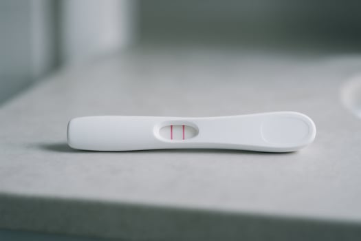 Positive pregnancy test on bathroom counter, concept of fertility, family planning, early pregnancy confirmation with copy space photo