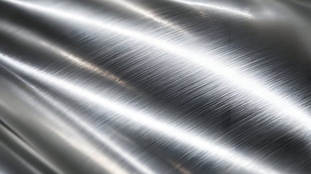 Luminous metal surface exhibiting light reflecting off a wavy texture with brushed patterns creating depth photo