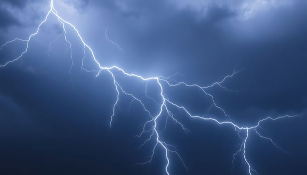 Lightning strikes in the sky over a dark blue sky photo