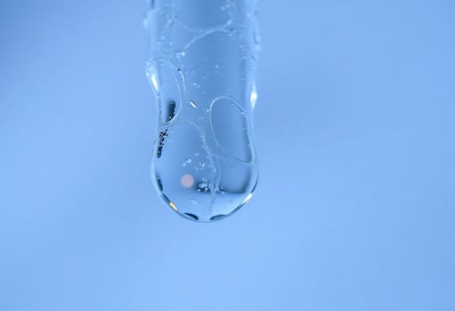 A close up of a water drop on a blue background photo