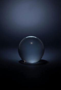 glass ball sitting on a black surface photo