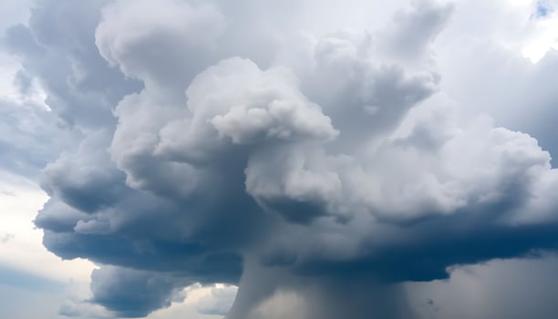 large cloud of dark clouds looms over a field photo