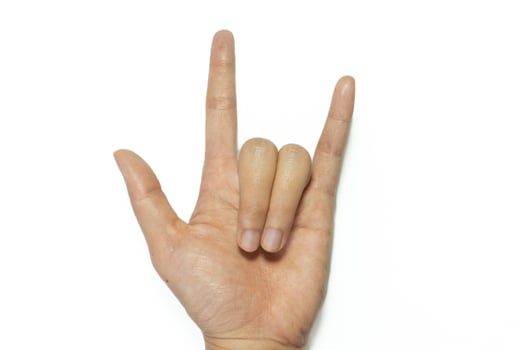 Female hand showing rock n roll sign or giving the devil horns gesture. photo
