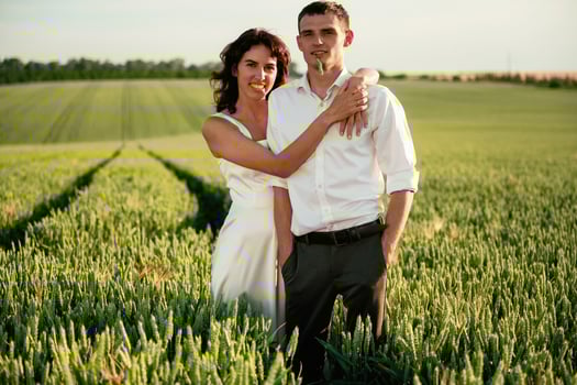 After ,the, wedding.. Lovely couple are on the agricultural field together photo