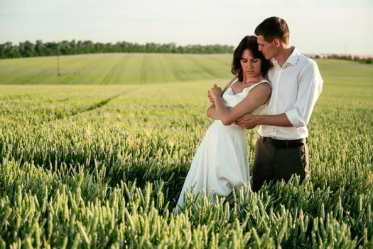 Against, beautiful, landscape. Lovely couple are on the agricultural field together photo