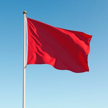 red flag waving in blue sky photo