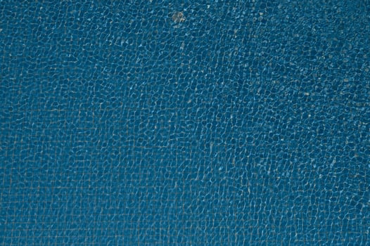 Abstract bright blue water texture in swimming pool with ripples and sunlight. photo