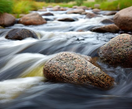 Flowing river water around Rocks in a natural setting photo
