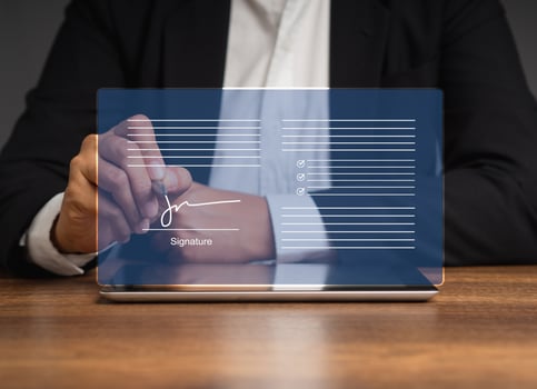 Businessman uses a stylus pen to sign electronic documents on a virtual screen while sitting in the office photo