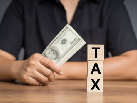 Tax day concept. Wooden cubes with the letters TAX stacked on the table photo