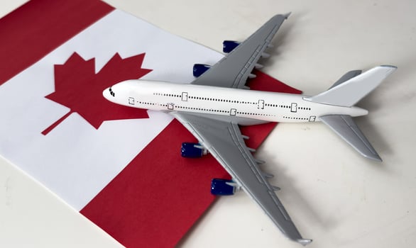 Flag of Canada and toy airplane. Flight travel concept photo