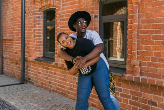 Happy african american couple laughing and hugging in the city street. Concept of love, friendship, fun photo