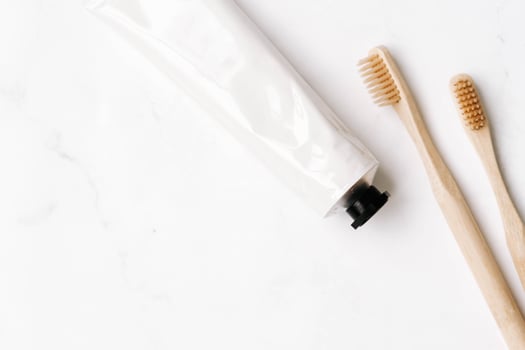 Top view of white metal tube and toothbrushes photo