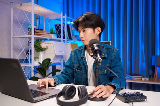 Creator working on podcast production with microphone and laptop. photo