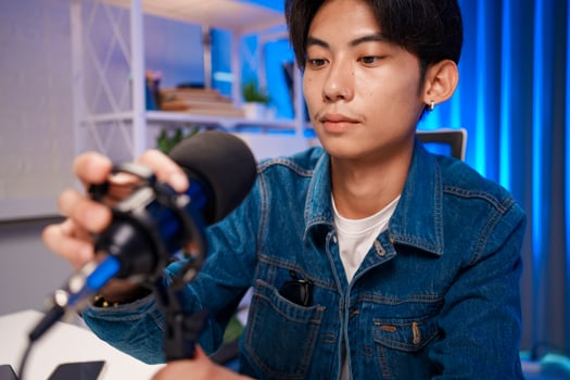 Content creator adjusting microphone for podcast recording in home studio photo