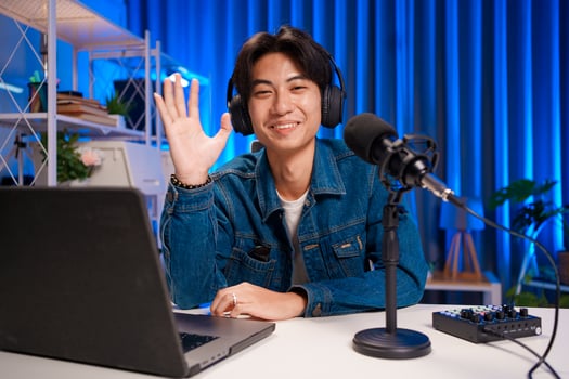 Podcast host waving to audience during live show photo