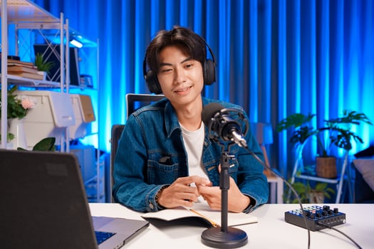 Young male podcastor into microphone during podcast photo